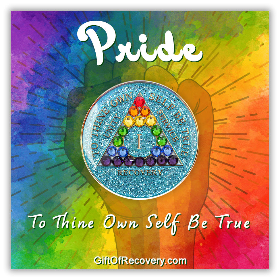 1 year deep sea aqua glitter AA medallion adorned with 21 genuine crystals representing the rainbow in the shape of the triangle to support the LBGTQIA+ community, stand proud at all times, the AA moto is embossed with 14k gold-plated brass and sealed with resin for a glossy finish, featured on a tie-dye 3x3 card with a silhouette of a fist and pride at the top along with to thine own self be true in bold white.