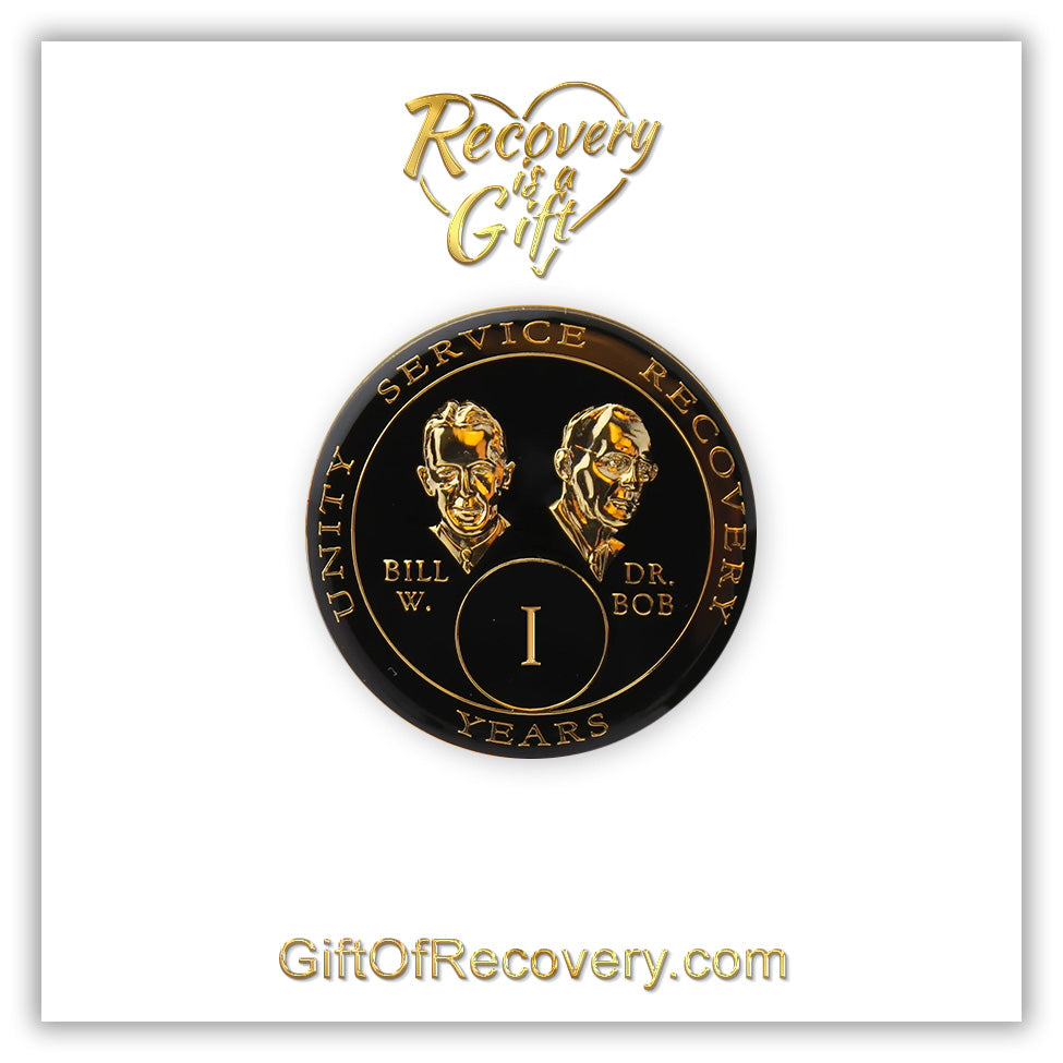1 year AA Bill & Bob black Onyx recovery medallion black around the rim with Unity, Service and recovery embossed 14k gold-plated brass, this medallion is to honor our founders and our time, stylized busts of Bill W. and Dr. Bob, with their names, are embossed 14k gold-plated brass, the medallion is sealed with resin for a glossy finish. seen on a white 3x3 card with recovery is a gift going through an open heart at the top and giftofrecovery.com on the bottom, both in the color gold.
