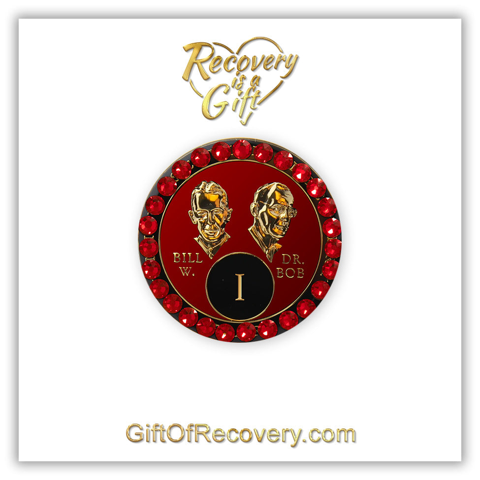 1 year AA Bill & Bob Ruby red recovery medallion with 28 genuine red Siam crystals around the rim, this medallion is to honor our founders and our time, stylized busts of Bill W. and Dr. Bob, with their names, in embossed 14k gold-plated brass, the medallion is sealed with resin for a glossy finish, seen on a white 3x3 card with recovery is a gift going through an open heart at the top and giftofrecovery.com on the bottom, both in the color gold.