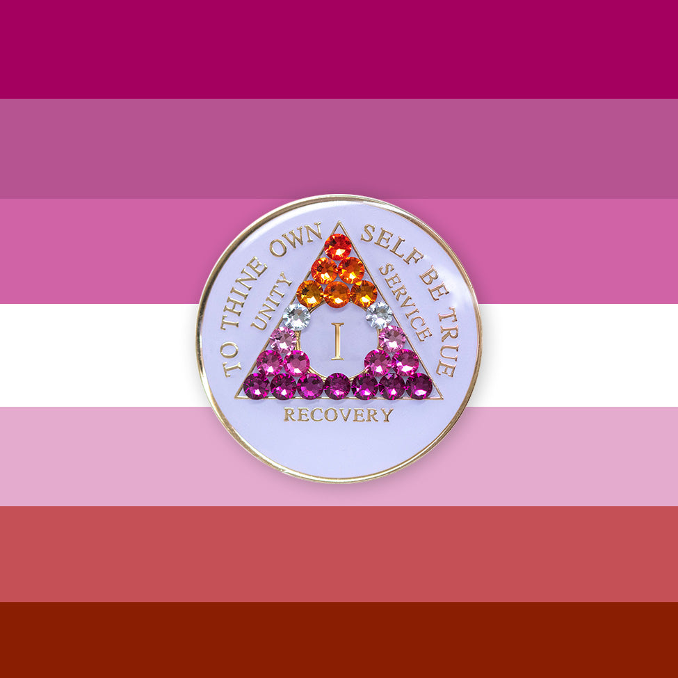 1 year AA medallion pearl white with 21 genuine crystals that form the triangle and are in the color of the Lesbian flag, colors are, to represent pride and sobriety, the AA slogan and three legacies are embossed with 14k gold-plated brass and sealed with resin for a glossy finish that will last and is scratch proof, pictured on an image of the Lesbian flag colors.