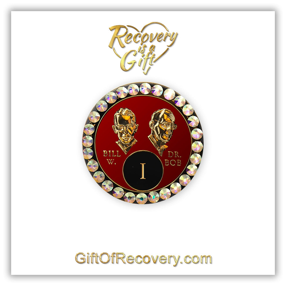 1 year AA Bill & Bob Ruby red recovery medallion with 28 genuine Aurora Borealis crystals around the rim, this medallion is to honor our founders and our time,  stylized busts of Bill W. and Dr. Bob, with their names, in embossed 14k gold-plated brass, the medallion is sealed with resin for a glossy finish, seen on a white 3x3 card with recovery is a gift going through an open heart at the top and giftofrecovery.com on the bottom, both in the color gold. 