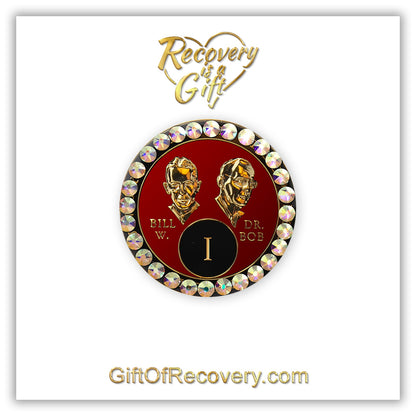 1 year AA Bill & Bob Ruby red recovery medallion with 28 genuine Aurora Borealis crystals around the rim, this medallion is to honor our founders and our time,  stylized busts of Bill W. and Dr. Bob, with their names, in embossed 14k gold-plated brass, the medallion is sealed with resin for a glossy finish, seen on a white 3x3 card with recovery is a gift going through an open heart at the top and giftofrecovery.com on the bottom, both in the color gold. 