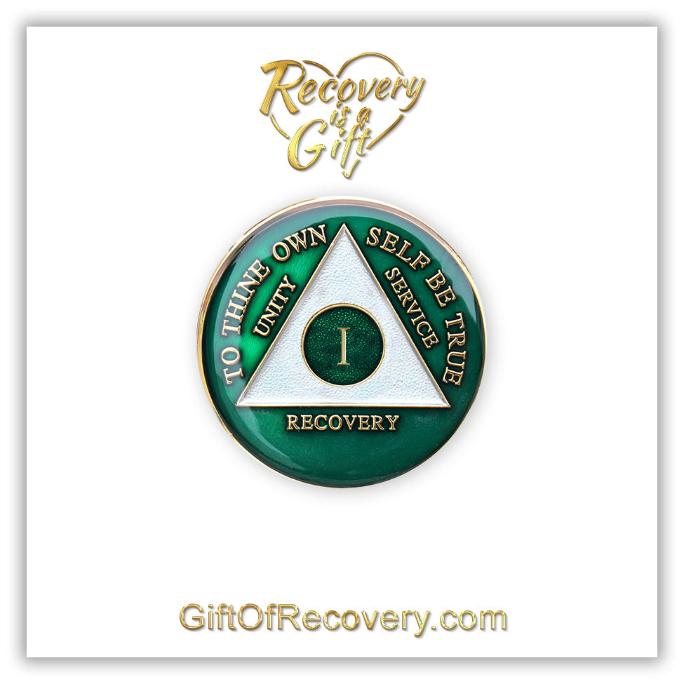 1 year AA medallion Emerald green, to symbolize luck and prosperity when you work the program, triangle is pearl white, to thine own self be true, unity, service, recovery, and roman numeral are embossed with 14k gold-plated brass, the recovery medallion is sealed with resin for a glossy finish that will last and is scratch free, pictured on a white 3x3 card with recovery is a gift going through an open heart at the top and giftofrecovery.com on the bottom, both in the color gold.