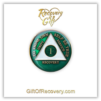 1 year AA medallion Emerald green, to symbolize luck and prosperity when you work the program, triangle is pearl white, to thine own self be true, unity, service, recovery, and roman numeral are embossed with 14k gold-plated brass, the recovery medallion is sealed with resin for a glossy finish that will last and is scratch free, pictured on a white 3x3 card with recovery is a gift going through an open heart at the top and giftofrecovery.com on the bottom, both in the color gold.