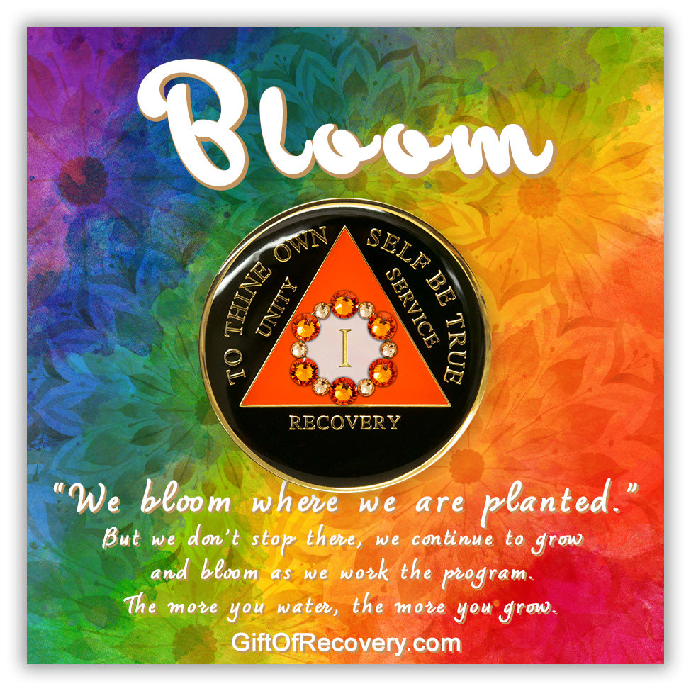 Recovery medallion 1 year black onyx 12 crystals that form the circle around the roman numeral representing growth in recovery, the triangle is sunset orange and the circle is pearl white, the lettering is embossed with 14k gold-plated brass and sealed in resin for a glossy finish that is scratch resistant, the medallion is on a 3x3 bold tie-dye card, with a silhouette of flowers, and the word bloom at the top and a paragraph on the bottom, emphasizing growth in the recovery journey.