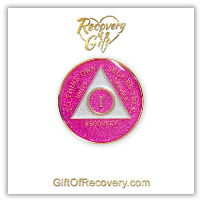 1 year AA medallion Princess pink glitter, the ultimate girl medallion, show off your feminine side, triangle is pearl white, to thine own self be true, unity, service, recovery, and roman numeral are embossed with 14k gold-plated brass, the recovery medallion is sealed with resin for a glossy finish that will last and is scratch free, pictured on a white 3x3 card with recovery is a gift going through an open heart at the top and giftofrecovery.com on the bottom, both in the color gold.