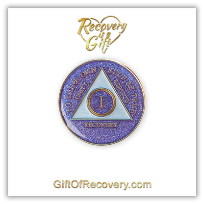 1 year AA medallion Amethyst Purple glitter, triangle is pearl white, to thine own self be true, unity, service, recovery, and roman numeral are embossed with 14k gold-plated brass, the recovery medallion is sealed with resin for a glossy finish that will last and is scratch free, pictured on a white 3x3 card with recovery is a gift going through an open heart at the top and giftofrecovery.com on the bottom, both in the color gold.