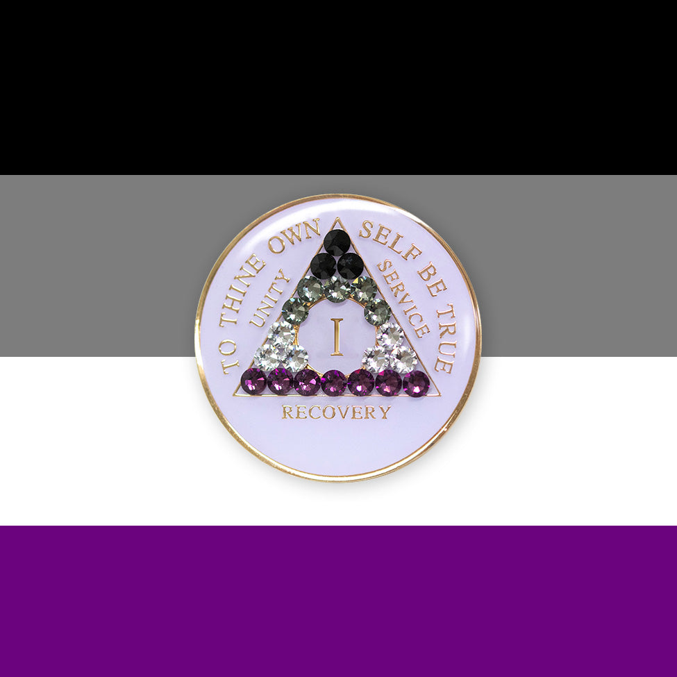 1 year AA medallion pearl white with 21 genuine crystals that make up the Asexual flag to represent recovery and pride, sobriety is a safe space, the AA slogan and three legacies are embossed with 14k gold-plated brass, sealed with resin for a glossy finish, pictured on a 3x3 card with the colors of the Asexual flag.