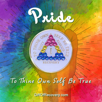 1 year AA medallion pearl white with 21 genuine crystals that form the triangle and are in the color of the Pansexual flag, to represent pride and sobriety, the AA slogan and three legacies are embossed with 14k gold-plated brass and sealed with resin for a glossy finish that will last and is scratch proof, pictured on  tie-dye 3x3 card with a silhouette of a fist and the words pride and to thine own self be true in bold white. 