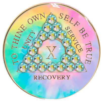 10 year AA medallion pastel tie-dye representing a psychic change that is needed in the recovery journey, with twenty-one Peridot AB genuine crystals, pink, blue, yellow, and green, in the shape of the triangle, with the AA moto and roman numeral embossed in 14k gold-plated brass, the medallion is sealed with resin for a glossy, scratch free finish.