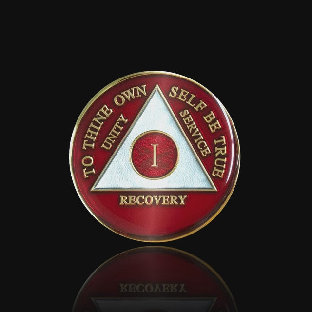 1 year AA medallion Ruby red, ignite the fire in your recovery and keep it lit, triangle is pearl white, to thine own self be true, unity, service, recovery, and roman numeral are embossed with 14k gold-plated brass, the recovery medallion is sealed with resin for a glossy finish that will last and is scratch free, featured in a 15 second video with a black background.