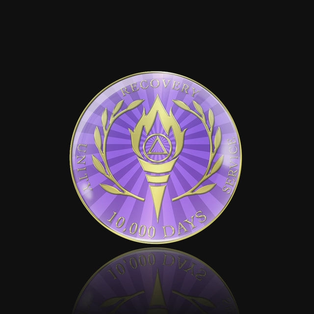 AA medallion with dark and light purple rays, a flame torch with an AA symbol in it and Greek leaves on either side, unity, service, recovery and 10,000 days surrounding it, sealed with resin for a glossy finish, featured in a video.