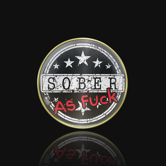 Sober as fuck AA medallion sober in black, as fuck in bold red, 5 stars above sober and 5 below, 14k gold-plated brass rim featured on a black 3x3 card white and red flames on the top and bottom, back is chill the fuck out in similar design, featured in a video.