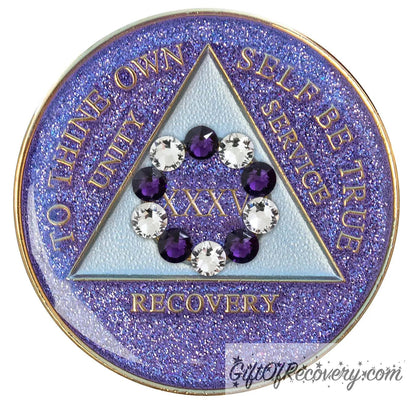 35 year AA medallion Amethyst purple glitter set in a circle around the roman numeral are 6 purple crystal and 6 CZ diamond, ten genuine crystal that represent the 10th step of AA, the triangle is pearl white and the AA moto is embossed with 14k gold-plated brass, sealed with resin for a shiny finish that will last and is scratch proof.