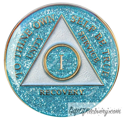 1 year AA medallion Aquamarine glitter, triangle is pearl white, to thine own self be true, unity, service, recovery, and roman numeral are embossed with 14k gold-plated brass, the recovery medallion is sealed with resin for a glossy finish that will last and is scratch free.