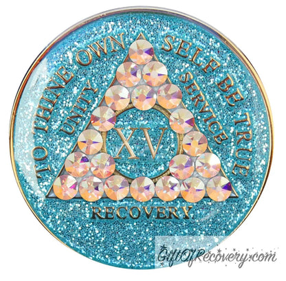 15 year deep sea aqua glitter AA medallion adorned with 21 genuine Aurora Borealis crystals representing the different colors and stages of our new lives, to thine own self be true, unity, service, recovery are embossed with 14k gold-plated brass and sealed with resin for a glossy finish that is scratch proof and will last.