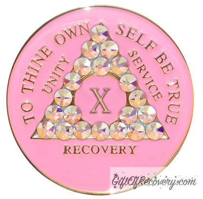 10 Year AA medallion princess pink with 21 Aurora Borealis CZ genuine crystals symbolizing beauty and change from working the program, AA slogan and 3 legacies are embossed with 14k gold-plated brass, sealed with resin for a lasting finish.