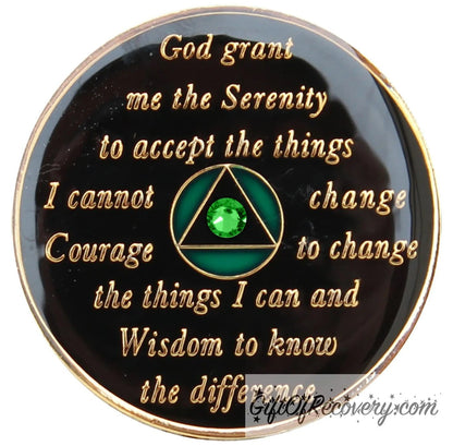 Back of Emerald green bloom CZ crystalized AA recovery medallion is black with the circle green and triangle black and has the serenity prayer, outer rim, and the circle triangle in the center 14k gold-plated brass, with one single green CZ genuine crystal in the center of the triangle, the recovery medallion is sealed with resin for a shiny finish.