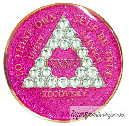 35 year AA recovery medallion in glitter princess pink and adorned with 21 diamond CZ genuine crystals shaped in the triangle to add sparkle to your sober princess journey in recovery, to thine own self be true, unity, service, recovery are embossed with 14k gold-plated brass and sealed with resin for a glossy finish that will last and is scratch proof.