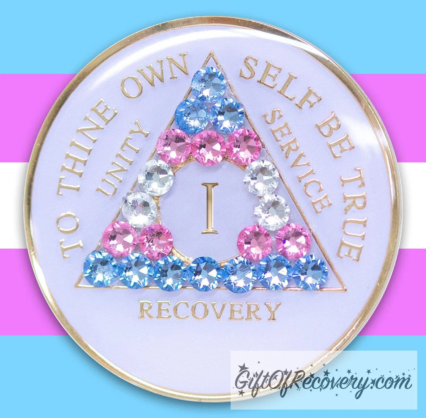 1 Year AA medallion pearl white with 21 genuine crystals that are the colors of the Transgender flag, to represent sobriety and pride for who you are, AA slogan and three legacies are embossed with 14k gold-plated brass and recovery medallion is sealed with resin for a glossy finish, pictured on a 3x3 example of the Transgender flag.