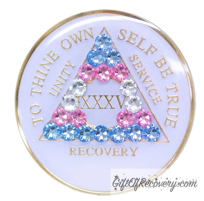 35 Year AA medallion pearl white with 21 genuine crystals that are the colors of the Transgender flag, to represent sobriety and pride for who you are, AA slogan and three legacies are embossed with 14k gold-plated brass and recovery medallion is sealed with resin for a glossy finish.